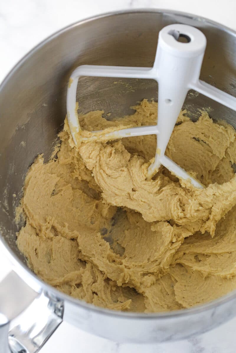 Mixing vanilla into creamed butter and sugars for cookie dough.