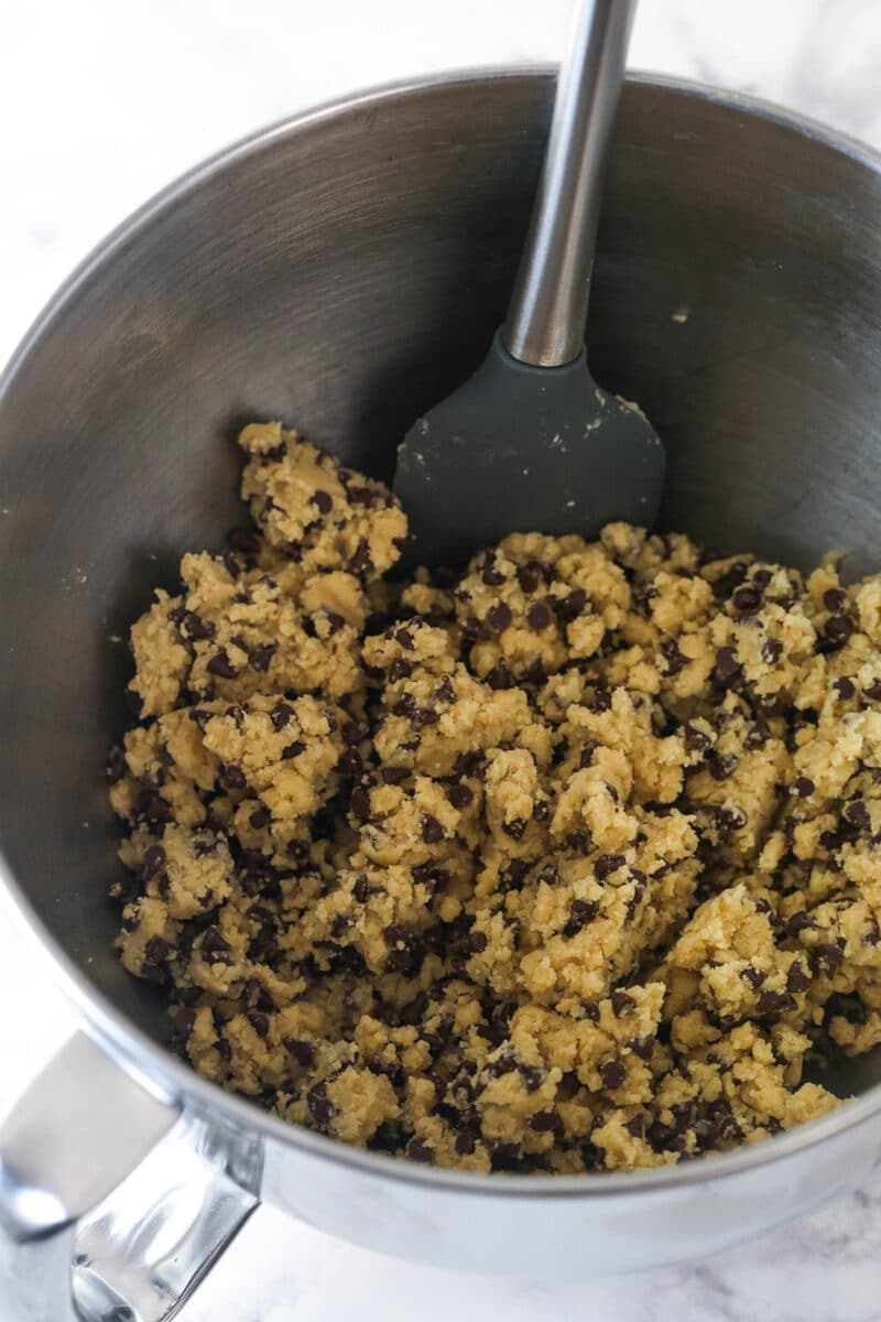 Folding mini chocolate chips into edible cookie dough.