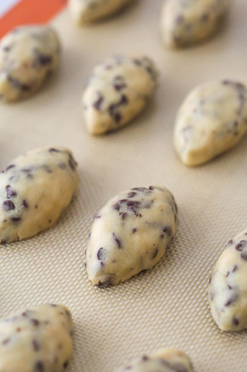 Cookie dough footballs on a silicon mat.