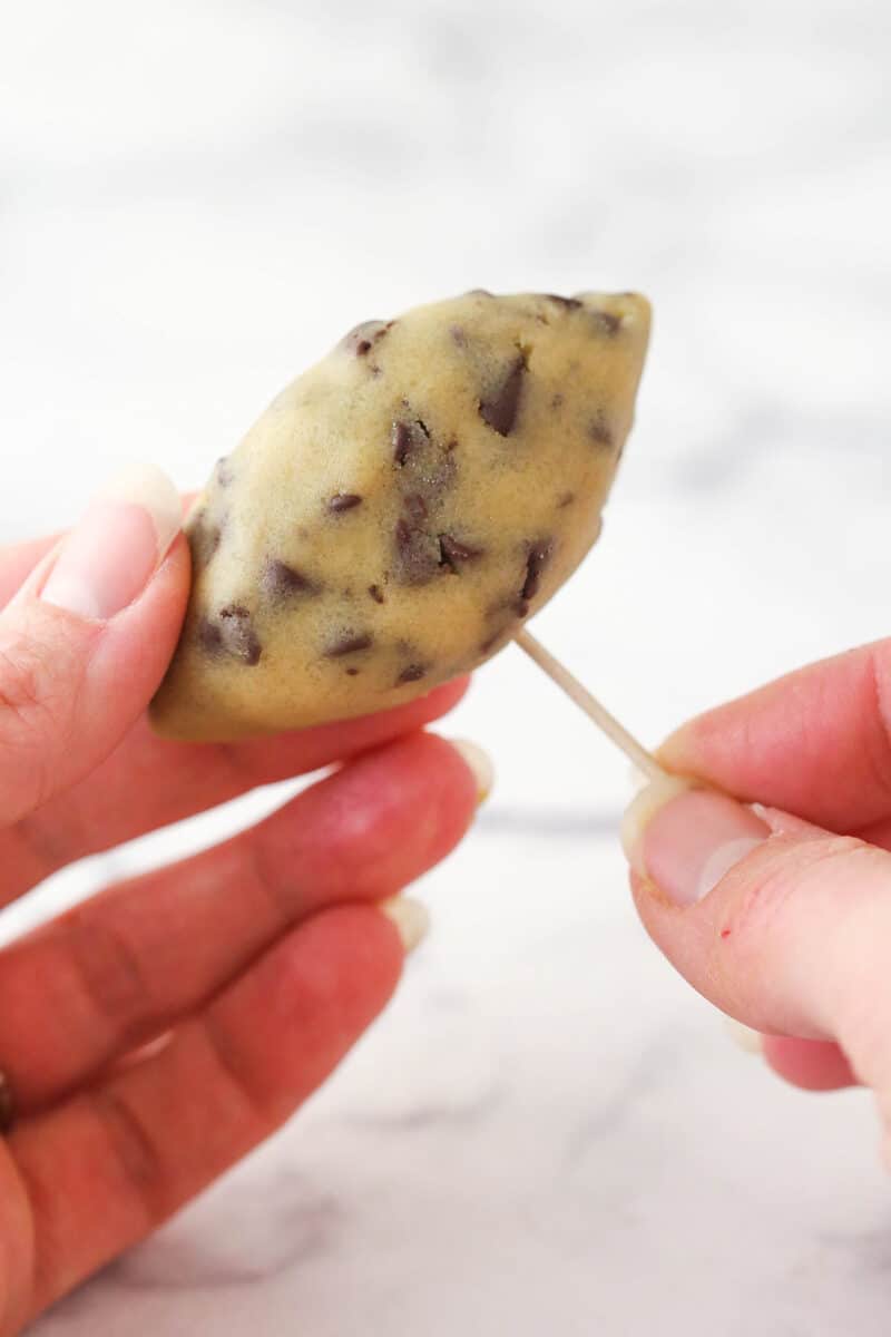 Sticking a toothpick in a cookie dough football.