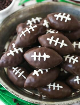 Closeup overhead image of cookie dough footballs on a serving plate.