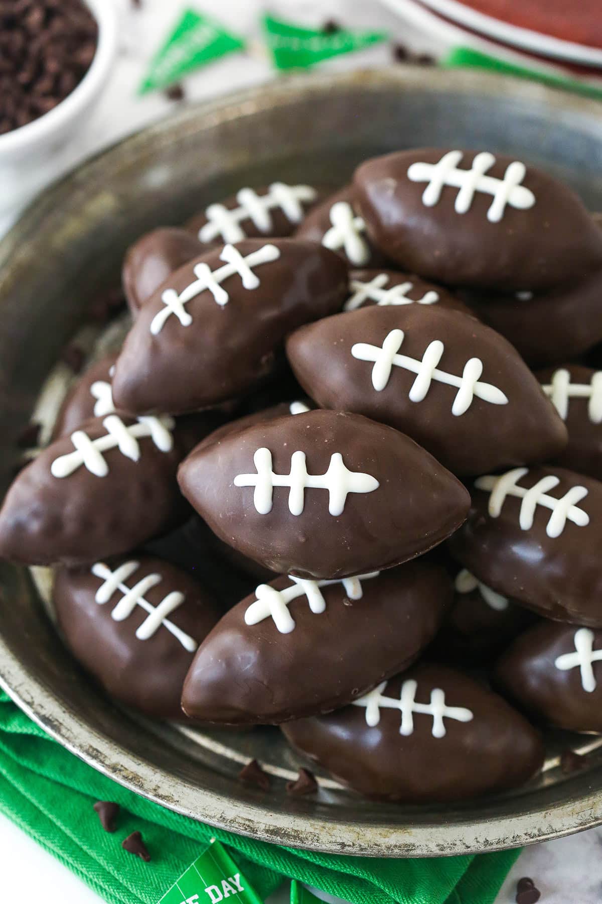 Closeup overhead image of cookie dough footballs on a serving plate.