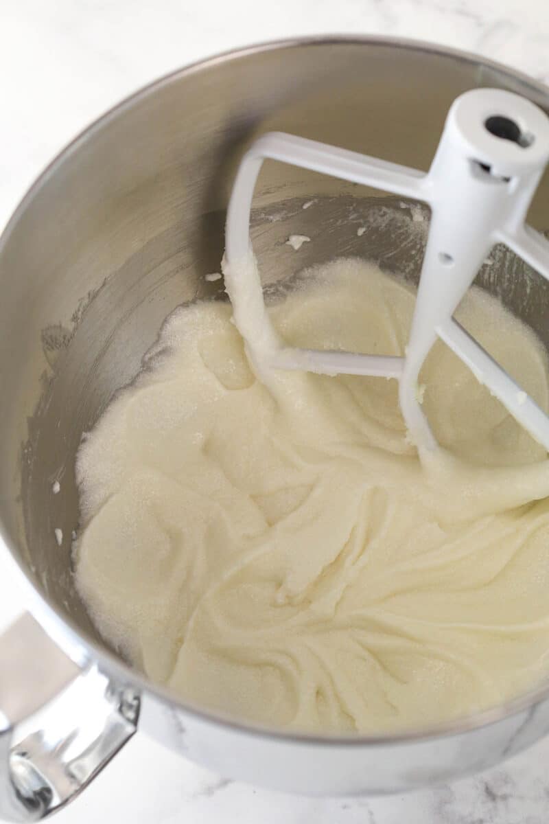 Mixing vanilla and sour cream into creamed butter, oil, and sugar.