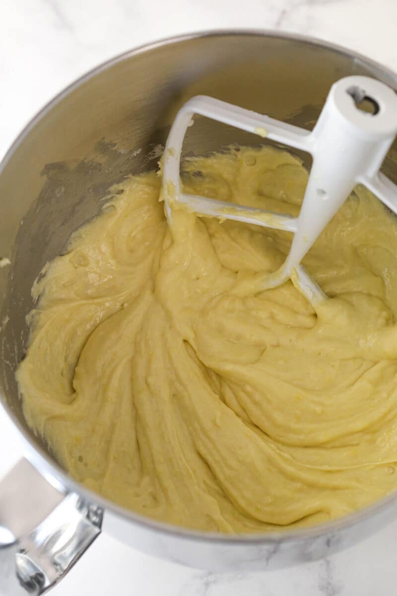Adding dry ingredients and milk, lemon juice, and lemon zest to cupcake batter.