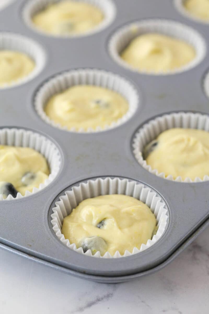 Filling cupcake liners with lemon blueberry cupcake batter.