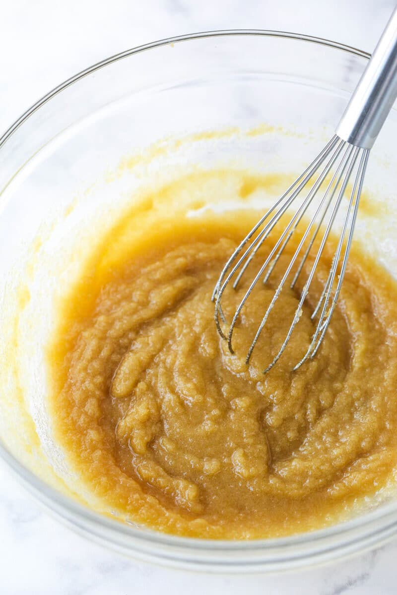 Whisking together melted butter, brown sugar, and granulated sugar.