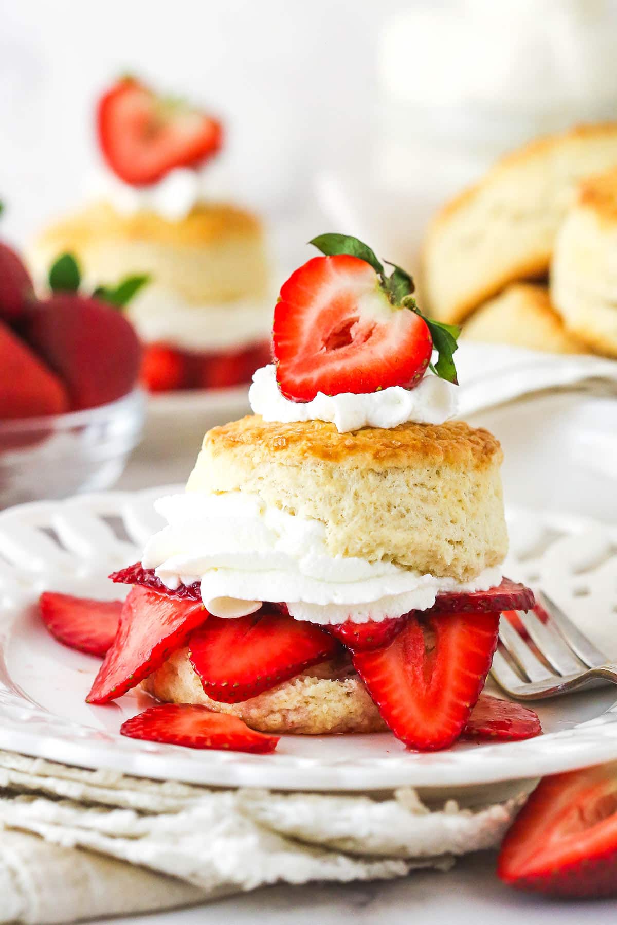 Strawberry shortcake on a plate with a fork.