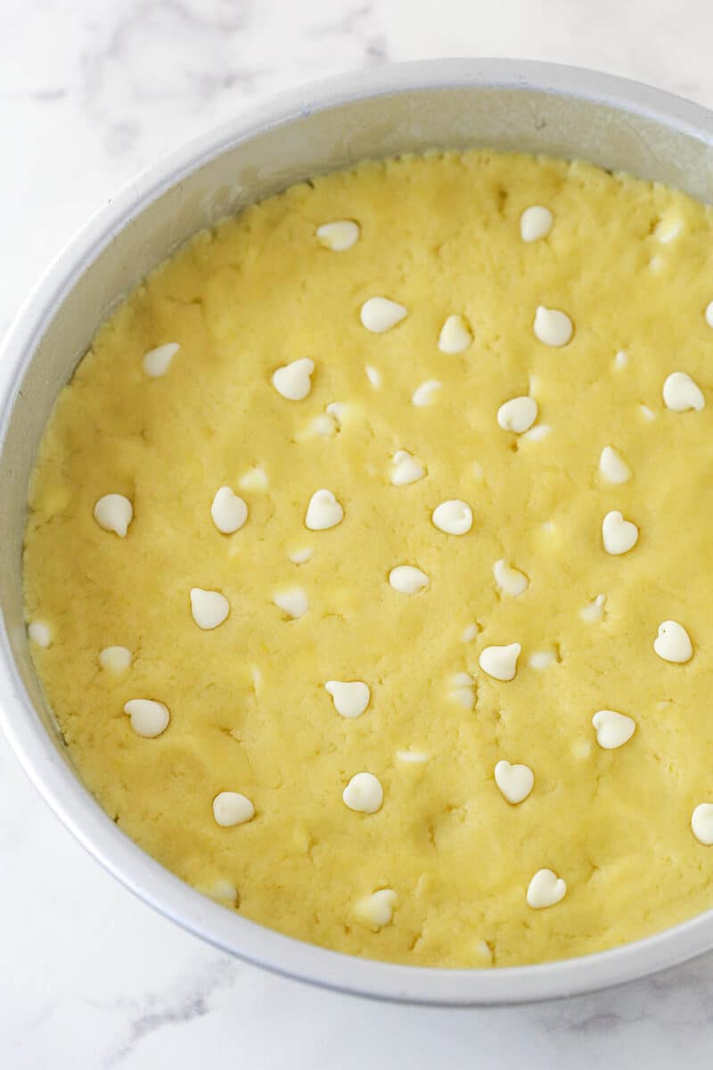 Lemon cookie cake dough pressed into a cake pan.