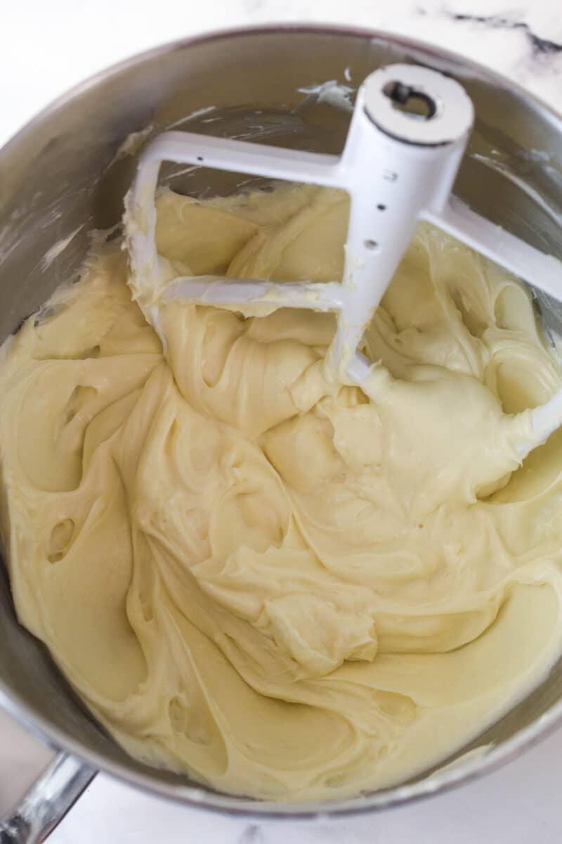 Beating together cream cheese, granulated sugar, and light brown sugar.