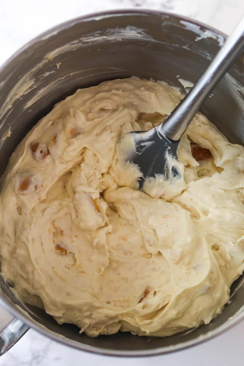 Folding whipped cream into no-bake cheesecake filling to add volume.