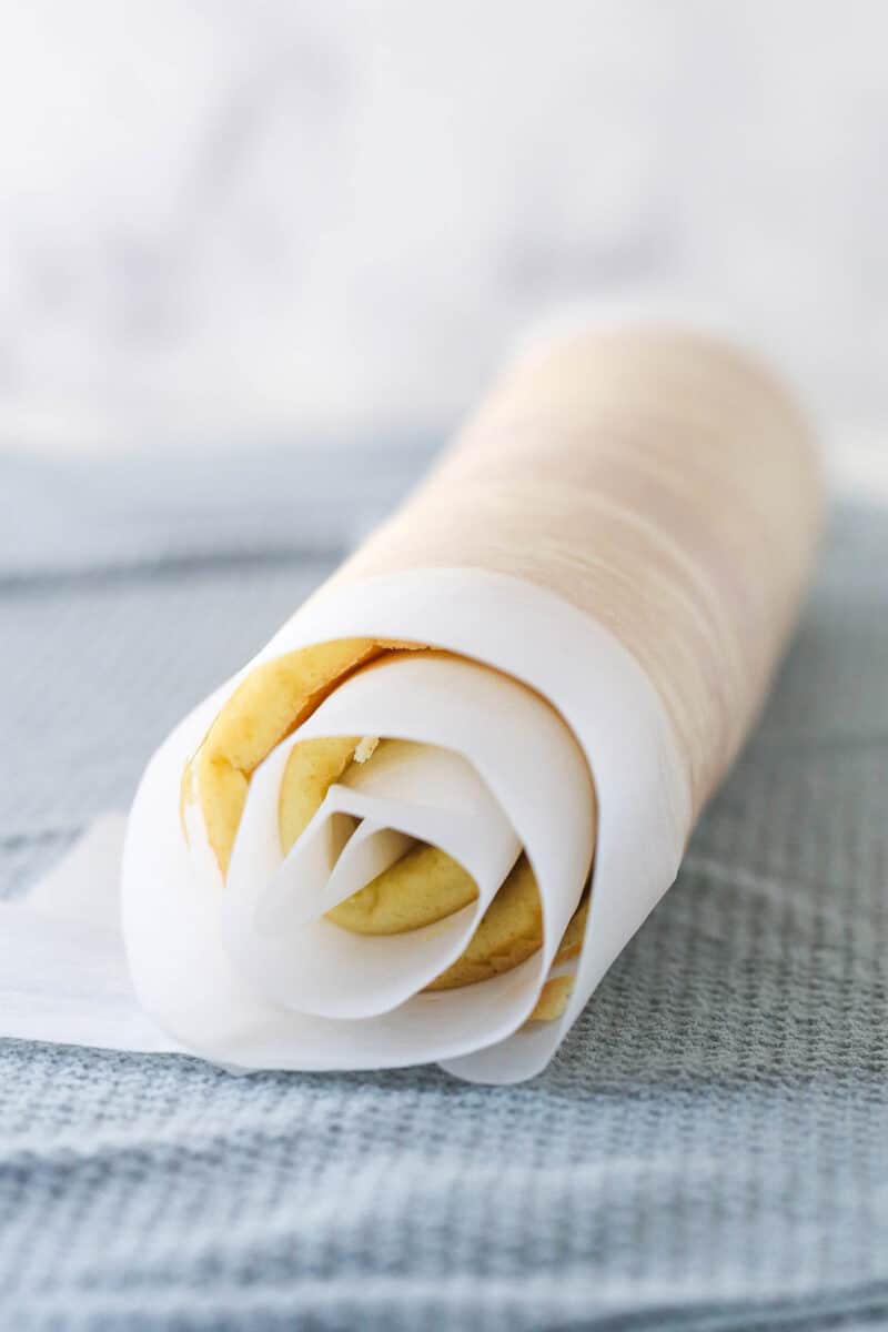 fully rolled cake roll sitting on a gray hand towel