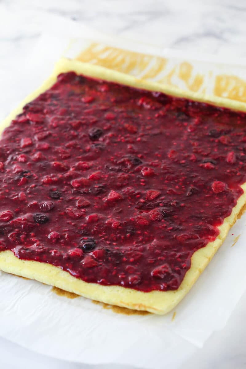 cake roll with berry filling spread evenly on top