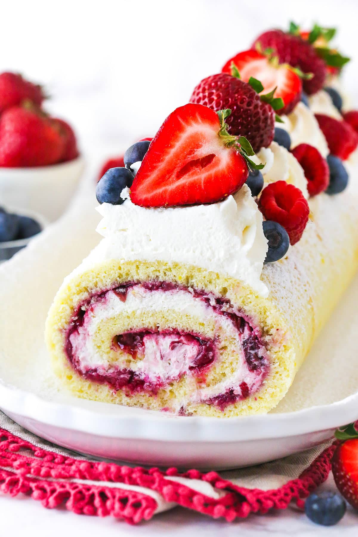 Berry Vanilla Cake Roll with the end sliced off so you can see the roll layers inside