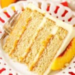 A slice of Brown Sugar Layer Cake With Peach Filling next to a silver fork on a white plate