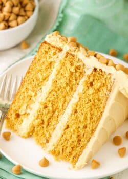 A slice of Ultimate Butterscotch Cake next to a fork on a white plate