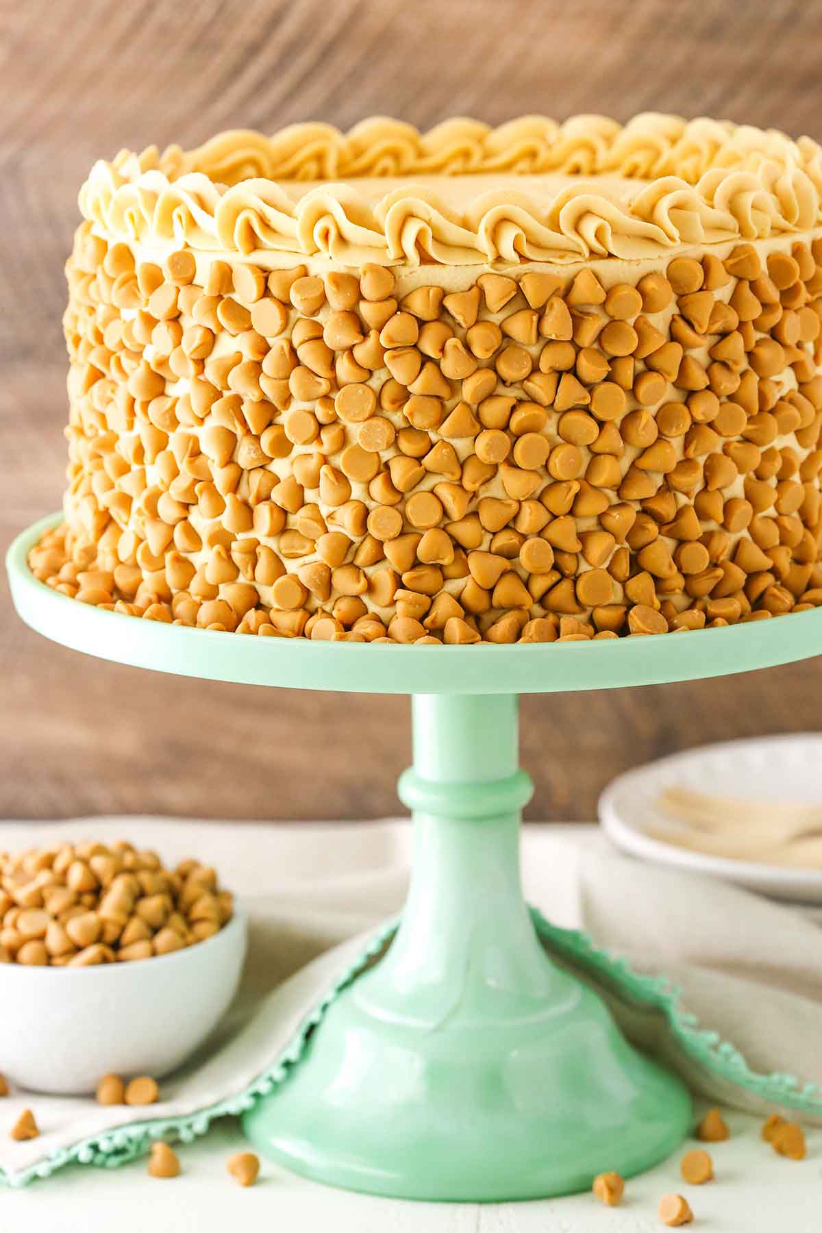 Side view of a full Ultimate Butterscotch Cake on a green cake stand