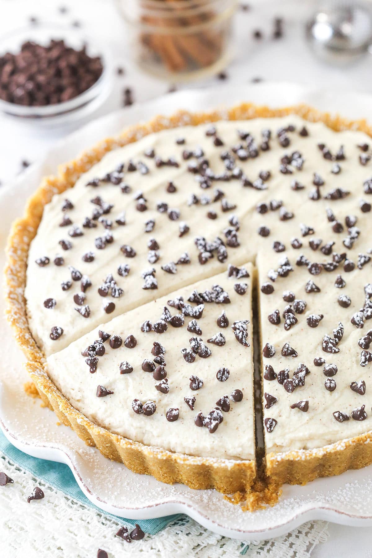 Cannoli tart on a serving platter with a slice cut and ready to serve.