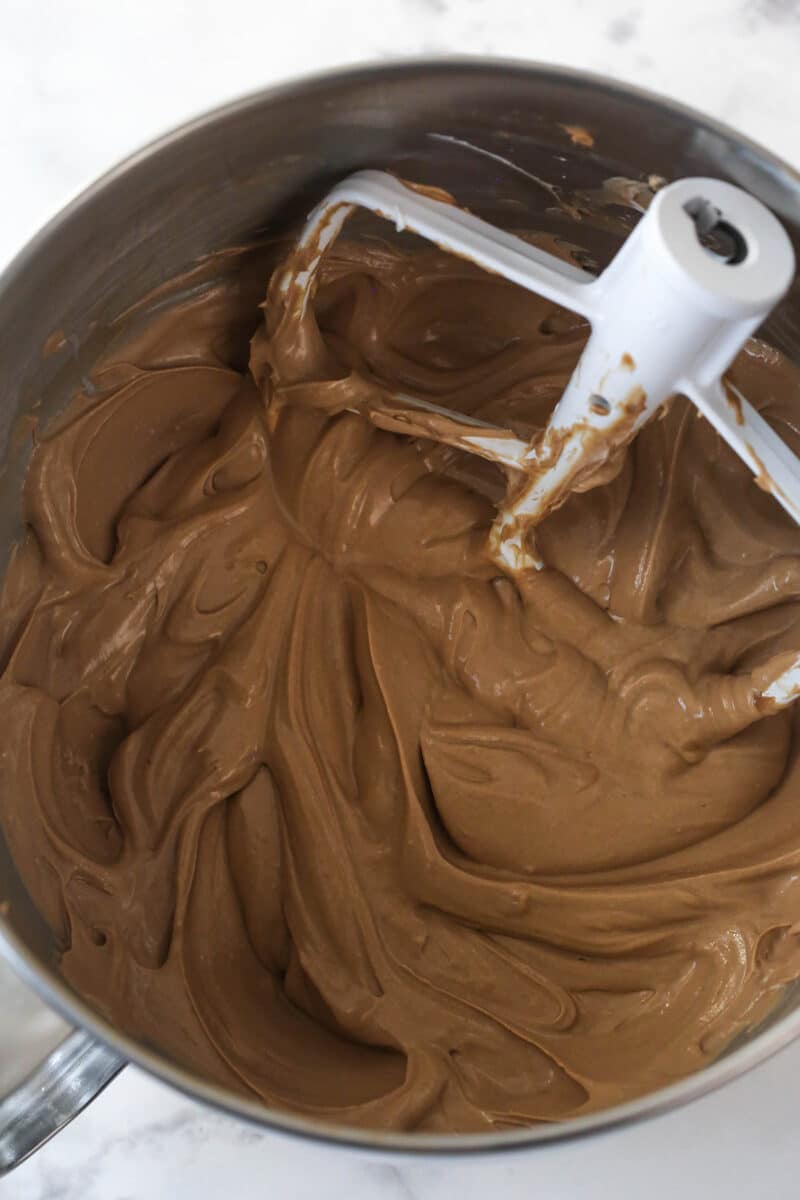 Stirring sour cream and vanilla into German chocolate cheesecake filling.