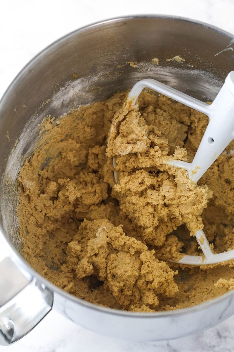 Adding the dry ingredients to peanut butter cookie cake dough.