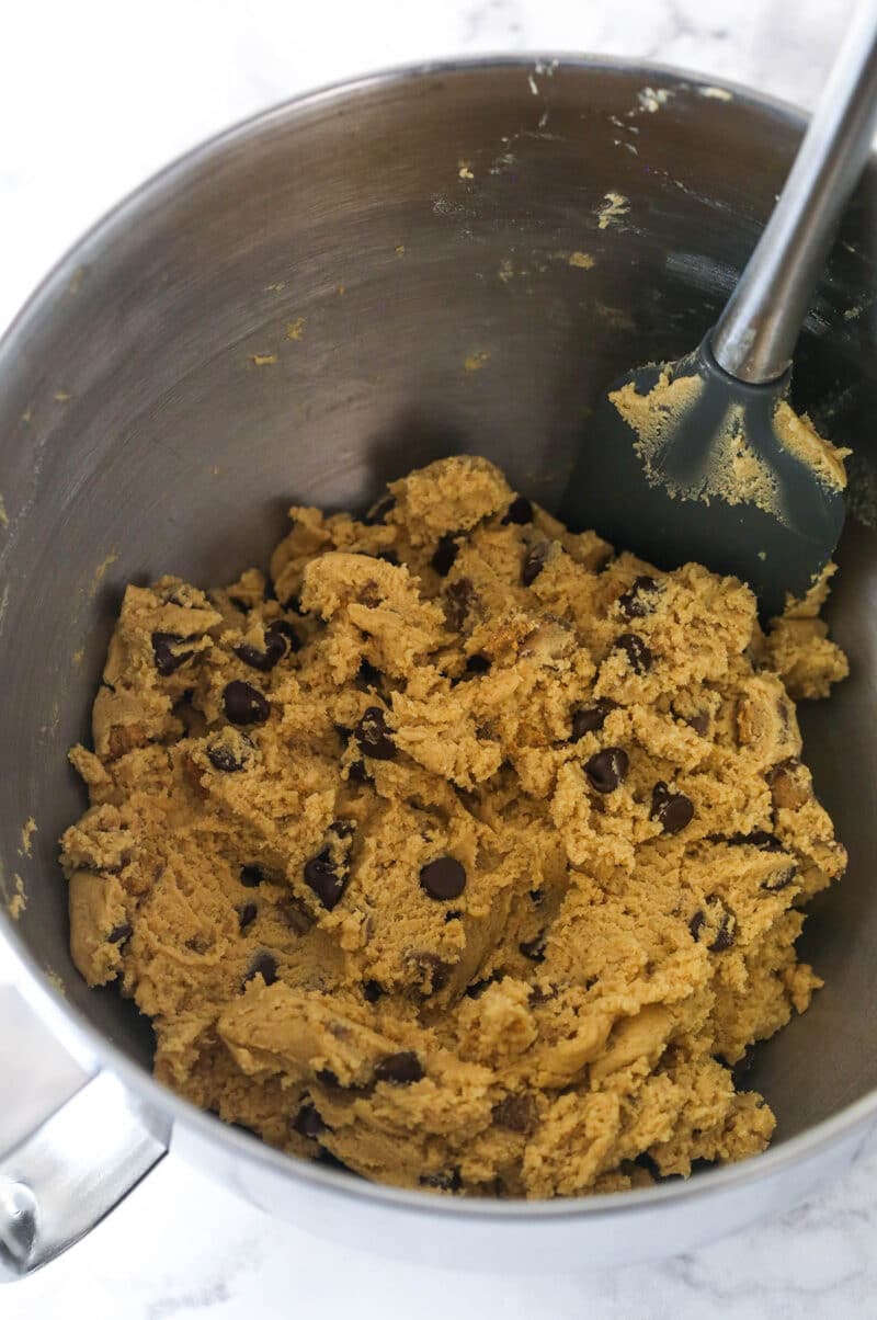 Folding Reese's and chocolate chips into peanut butter cookie cake dough.