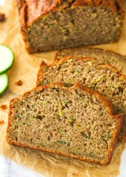 Overhead image of zucchini bread cut into slices on a cutting board.