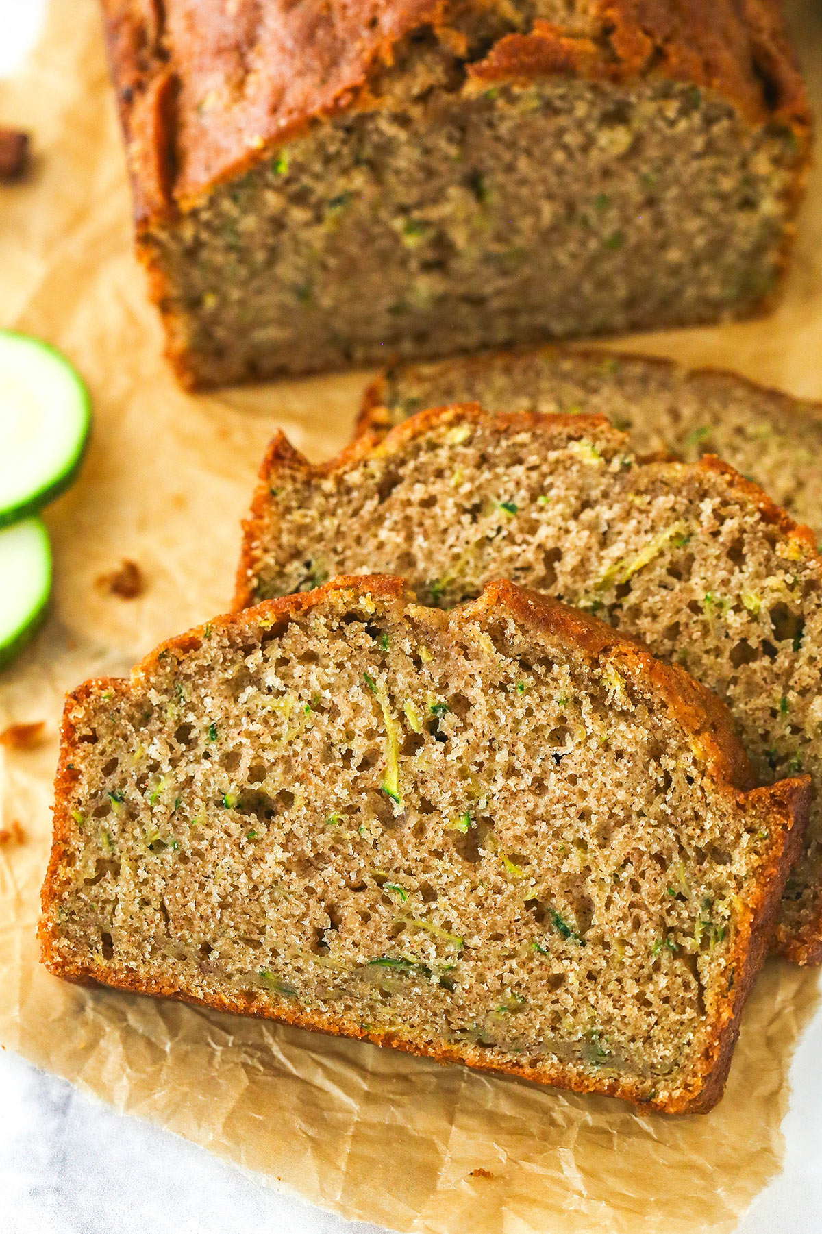 Overhead image of zucchini bread cut into slices on a cutting board.