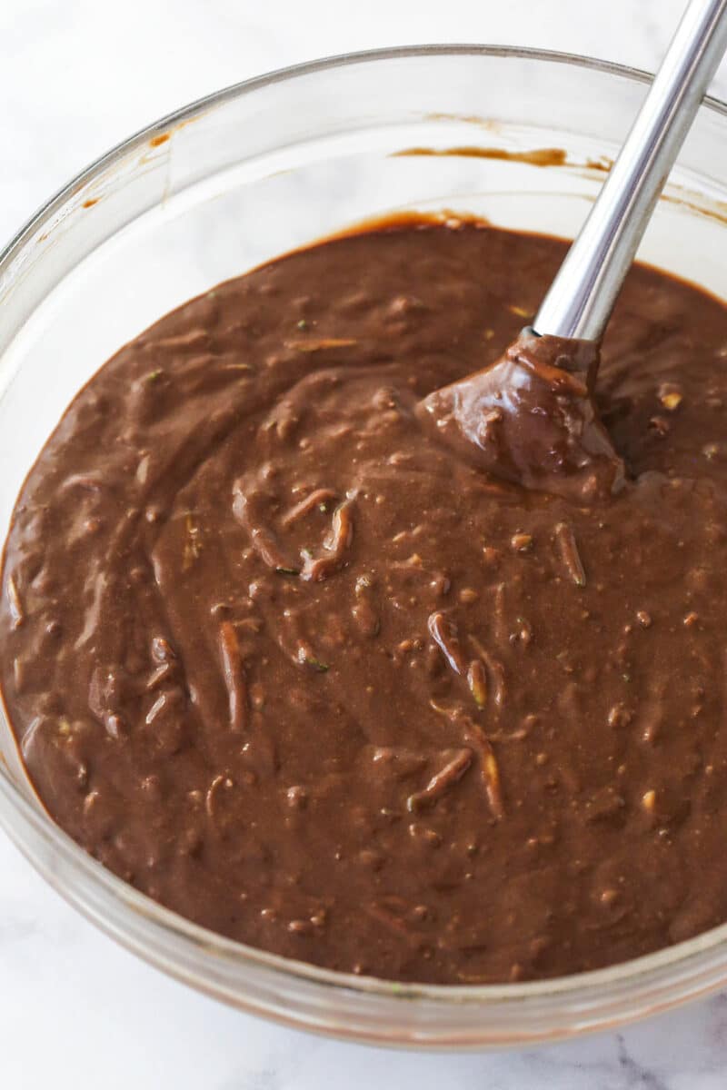 Folding shredded zucchini into chocolate cake batter.