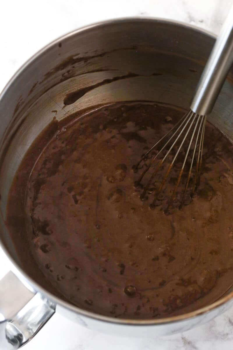 A whisk combining chocolate cake batter ingredients