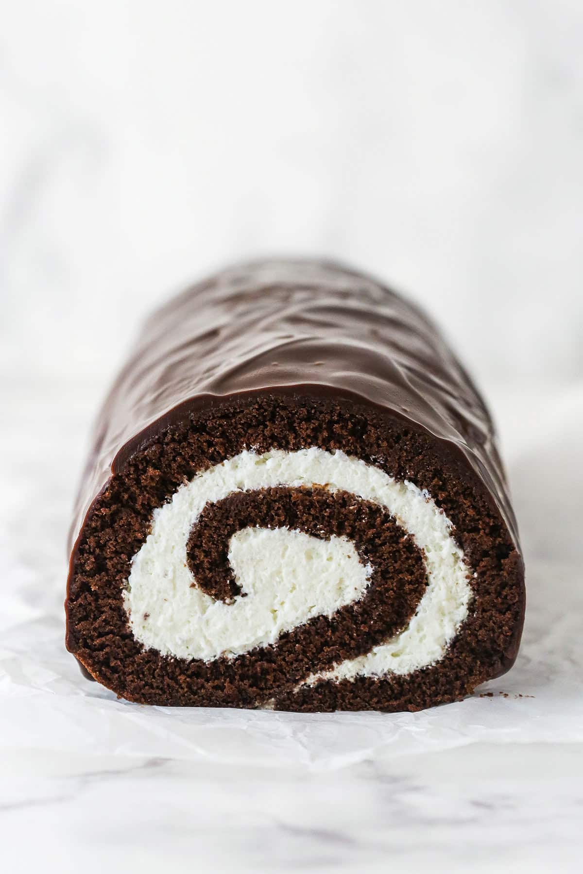 A chocolate Swiss roll cake on a marble counter