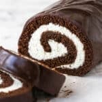 A homemade chocolate Swiss roll with two pieces sliced