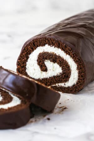 A homemade chocolate Swiss roll with two pieces sliced