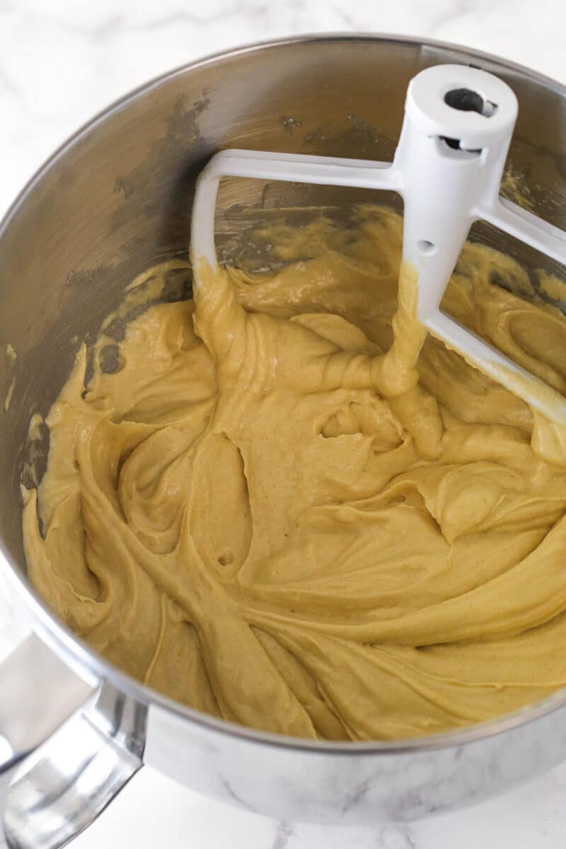 A mixing bowl with cake batter that has had dry ingredients mixed into it.