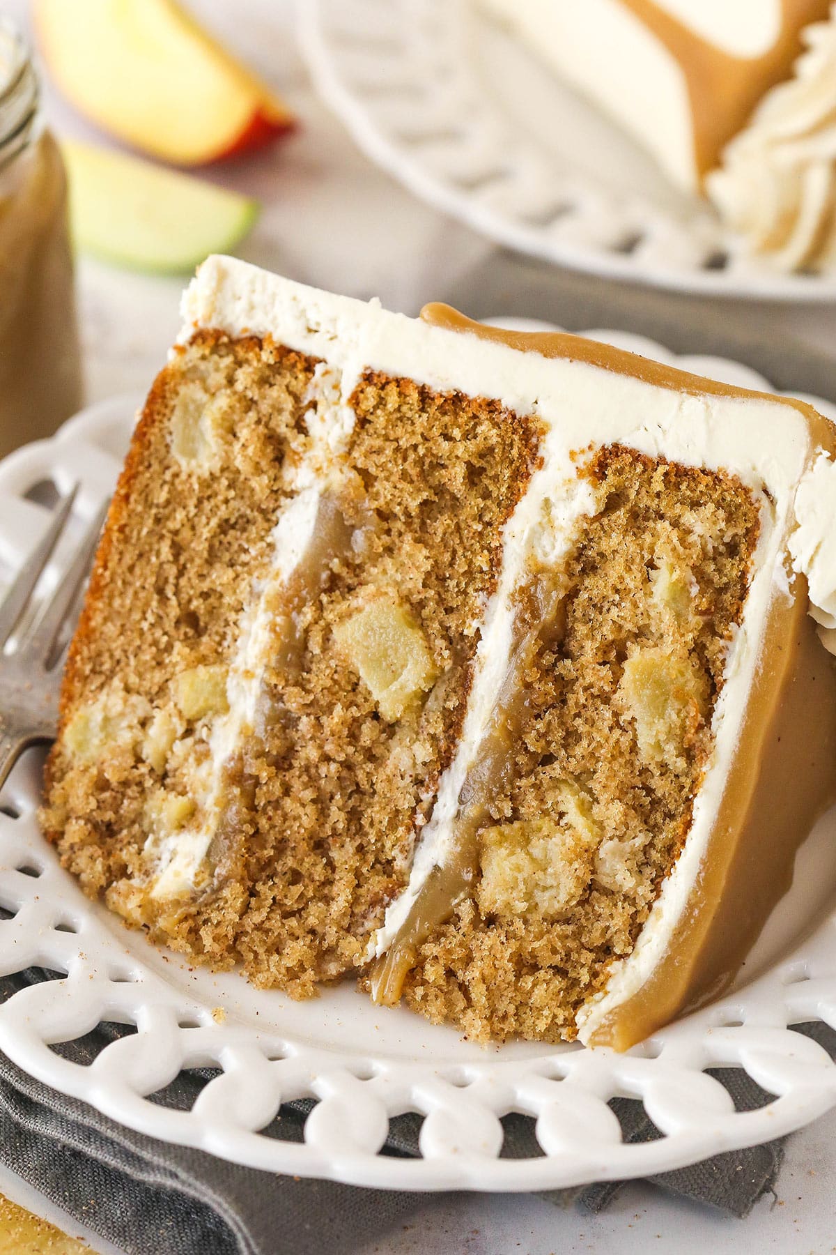 A slice of Caramel Apple Layer Cake on a small white plate.