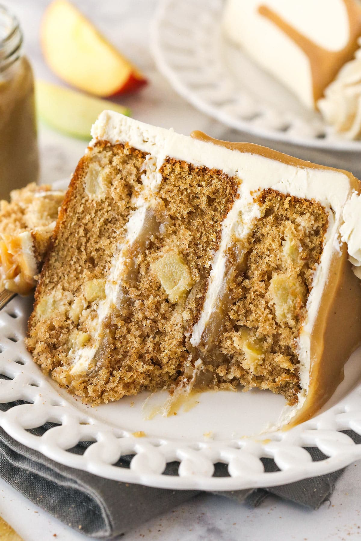 A slice of Caramel Apple Layer Cake on a small plate with a bite taken out of it.