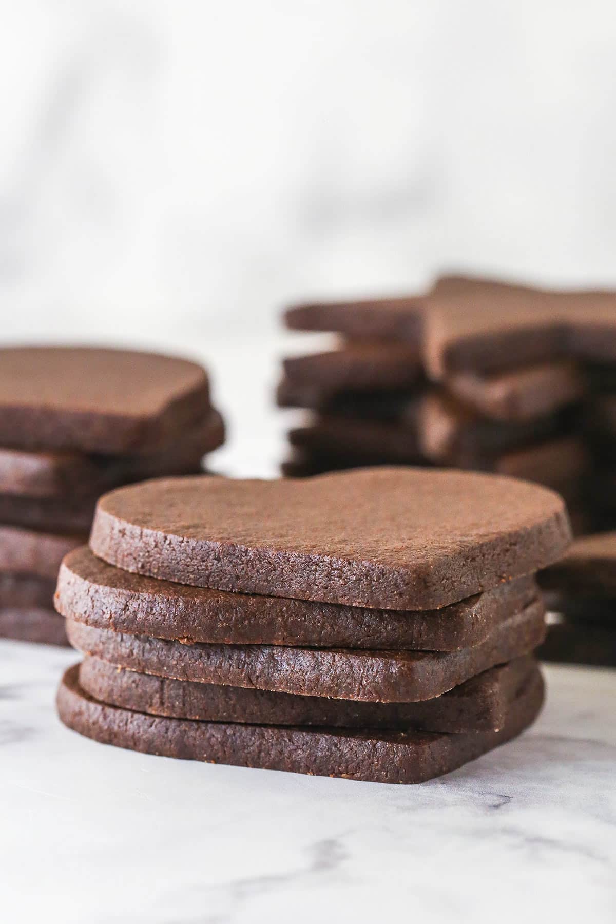 Chocolate cutout cookies stacked on top of each other