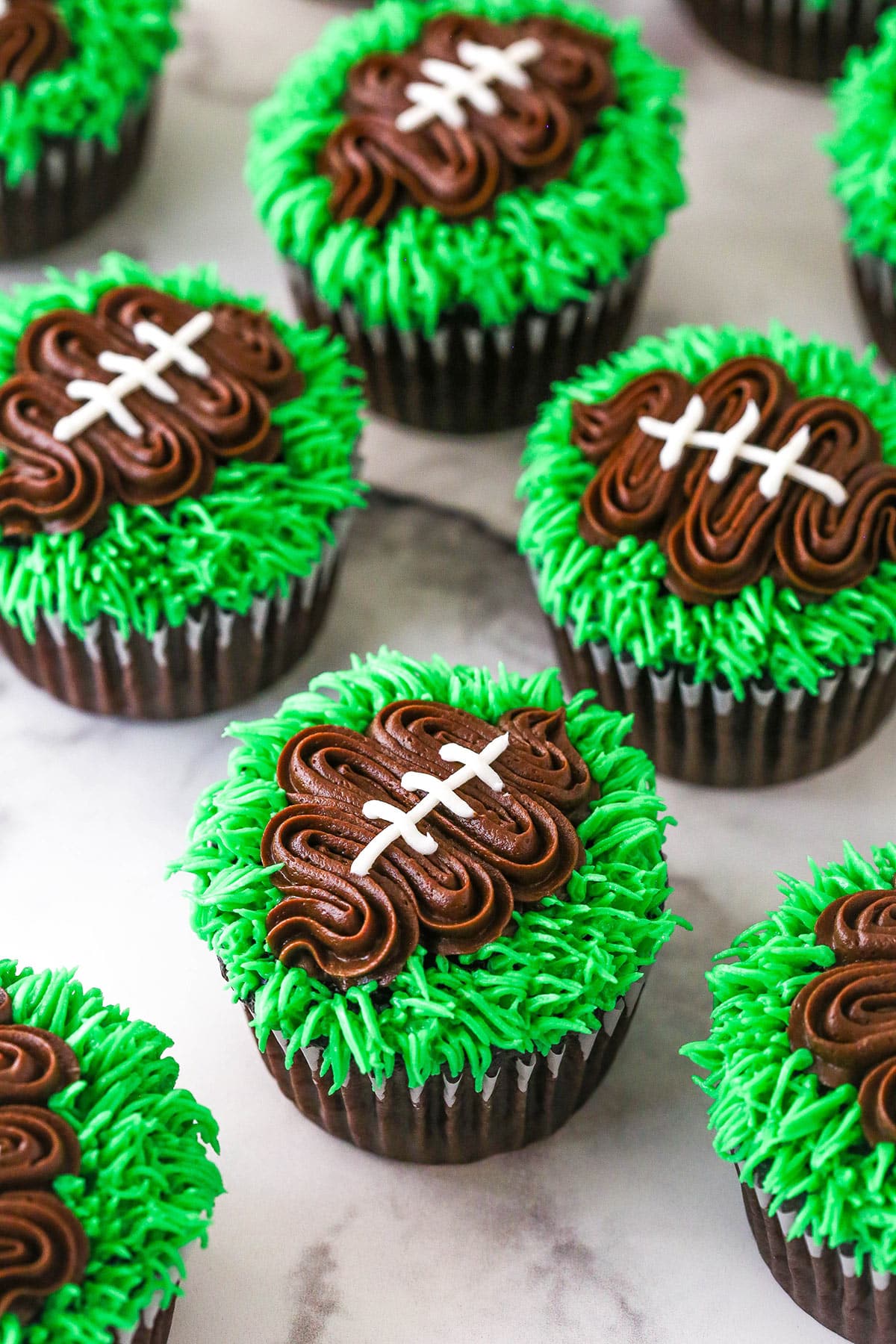 finished football cupcakes set on a marble background