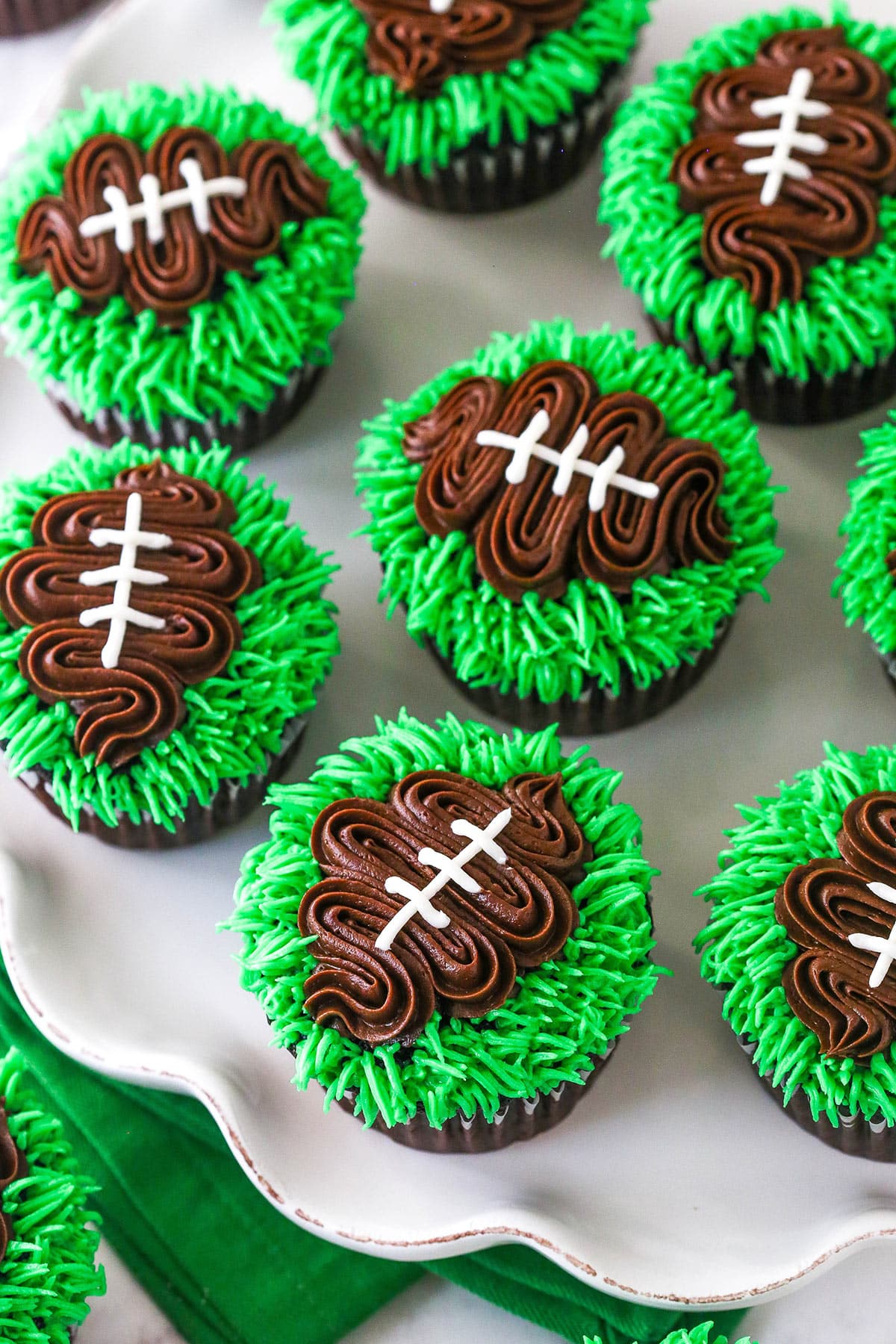 overhead image of football cupcakes on white ruffle platter