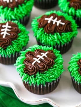 football cupcakes on white ruffle platter