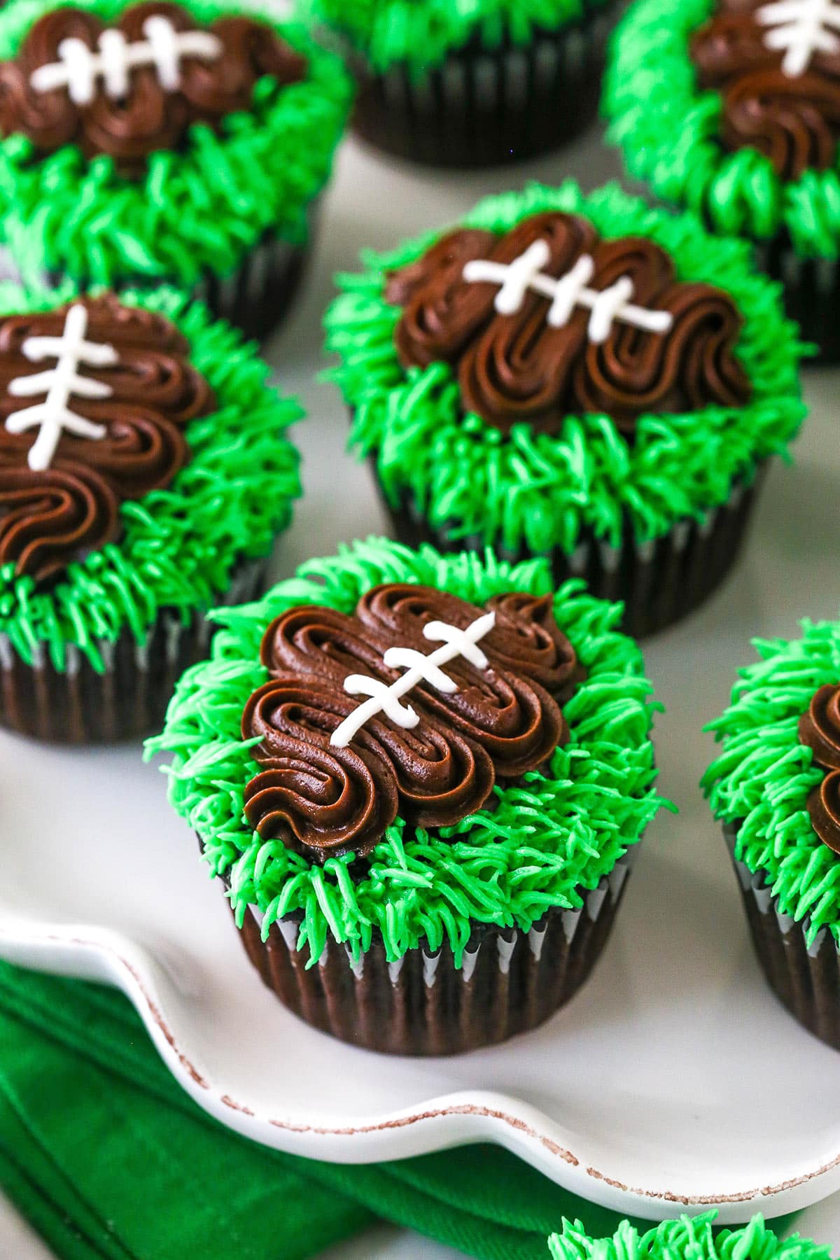 football cupcakes on white ruffle platter