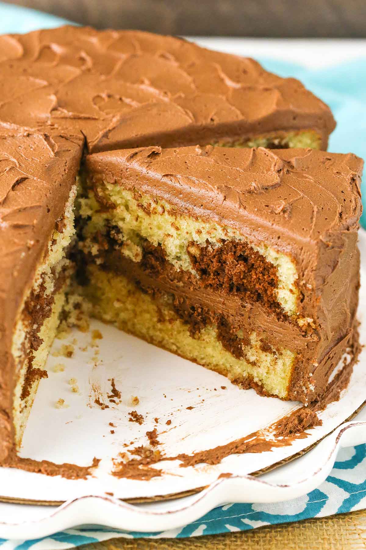 A Marble Cake with a serving removed on a white platter