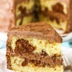 A slice of Marble Cake next to a fork on a white plate