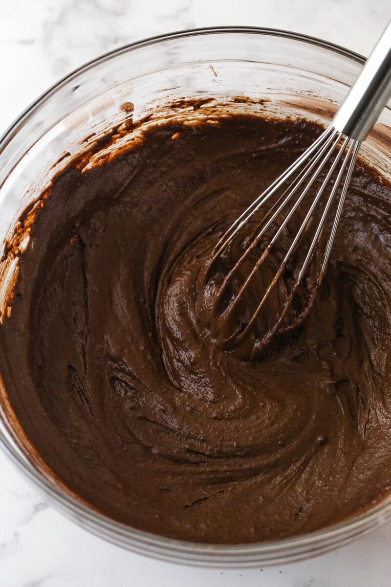 A whisk in chocolate cake batter