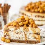 Side view of a slice of Apple Cinnamon Cheesecake on a small white plate.