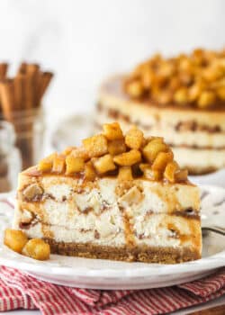 Side view of a slice of Apple Cinnamon Cheesecake on a small white plate.