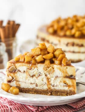 Side view of a slice of Apple Cinnamon Cheesecake on a small white plate.