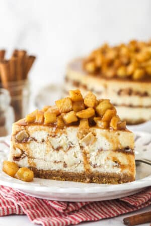 Side view of a slice of Apple Cinnamon Cheesecake on a small white plate.