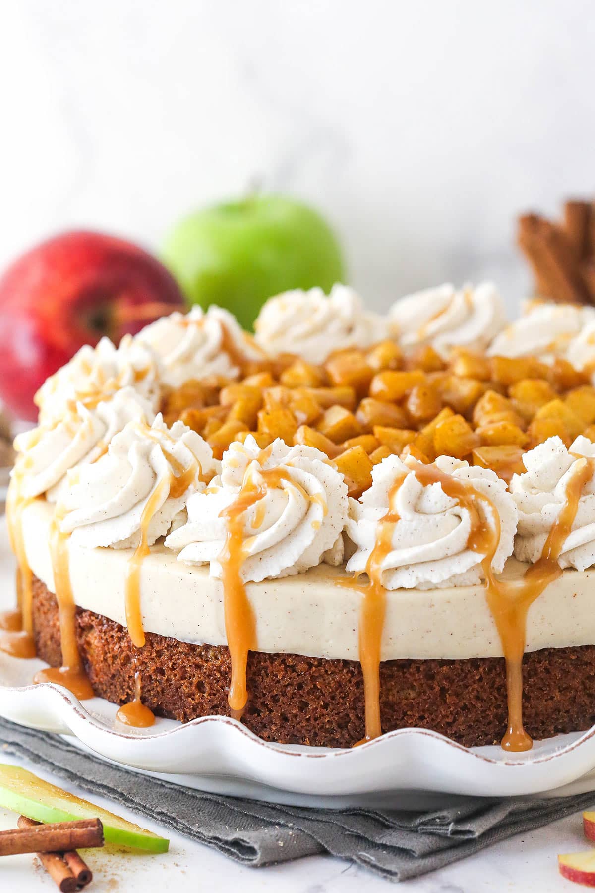 A Caramel Apple Blondie Cheesecake on a white ruffled cake plate.