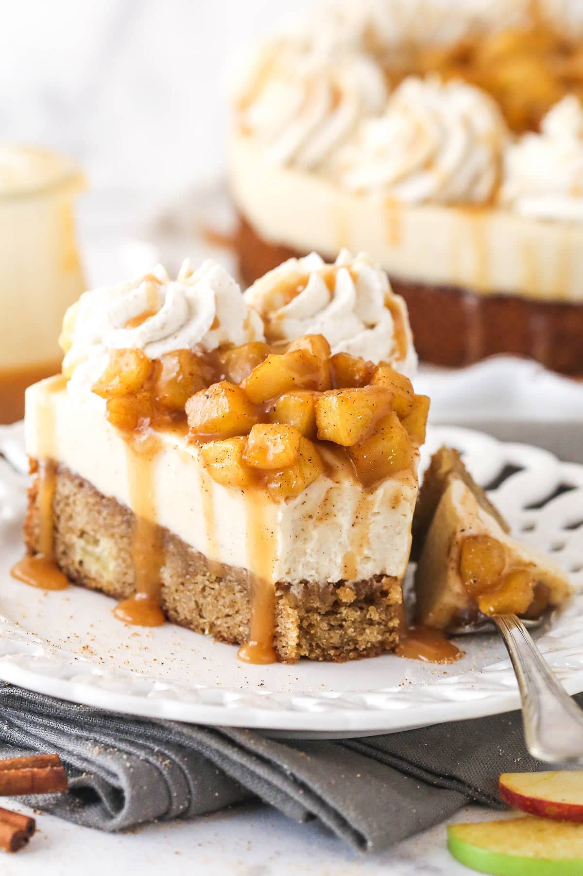 A slice of Caramel Apple Blondie Cheesecake with a bite removed on a small white plate.