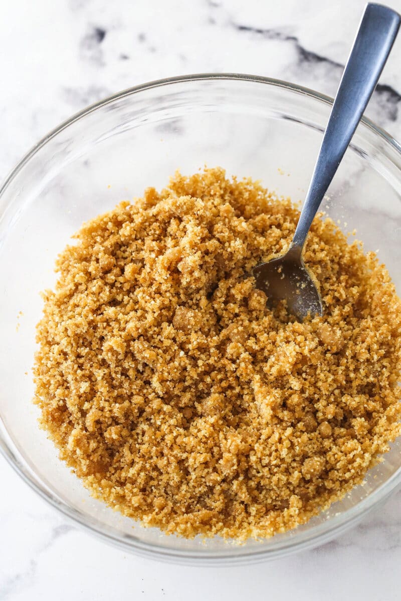 Vanilla wafer pie crust mixture in a glass mixing bowl.