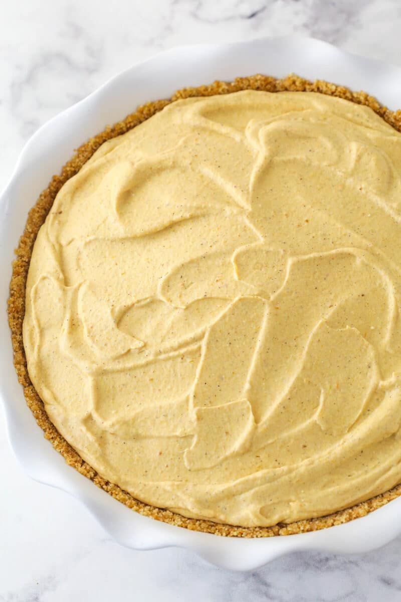 A Pumpkin Ice Cream Pie with the filling in it.